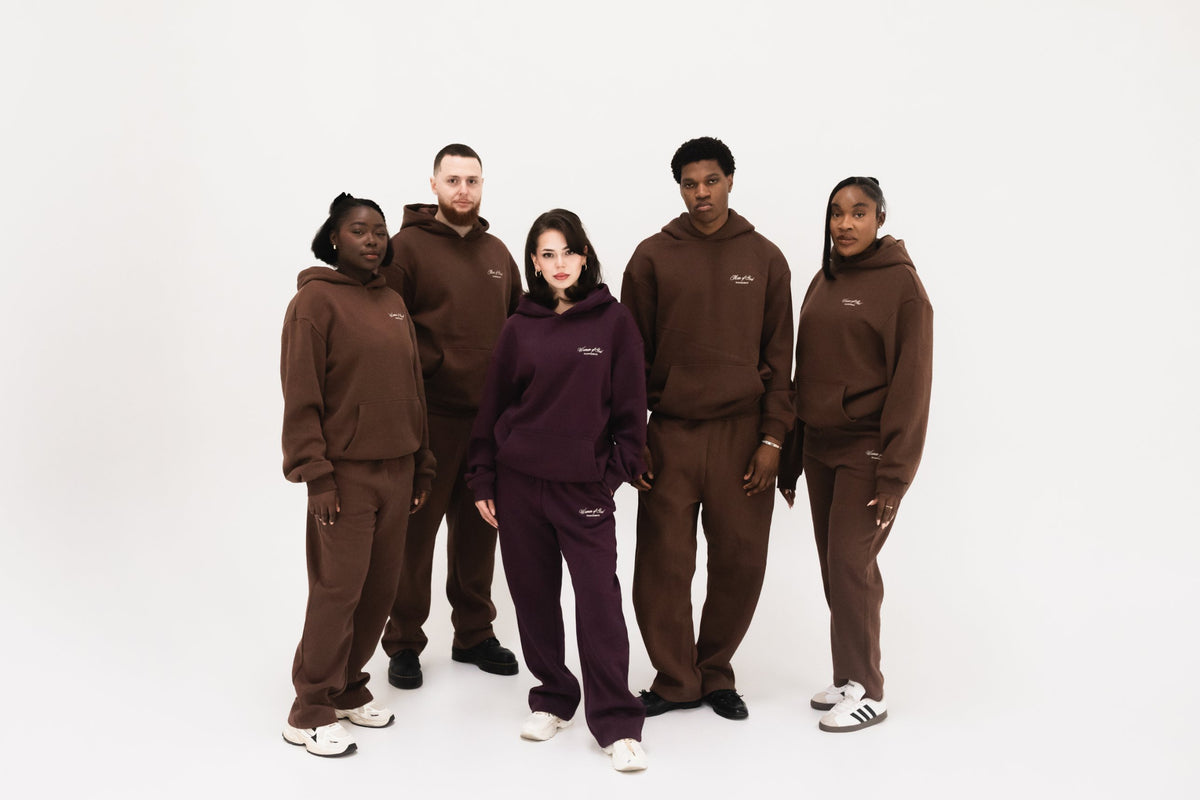 Godfidence Rooted Kollektion – fünf Personen in braunen und lila Hoodie-Sets